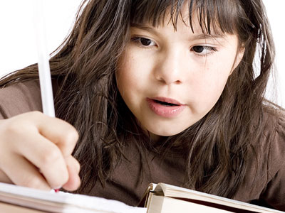 This is an image of a girl writing in a notebook.